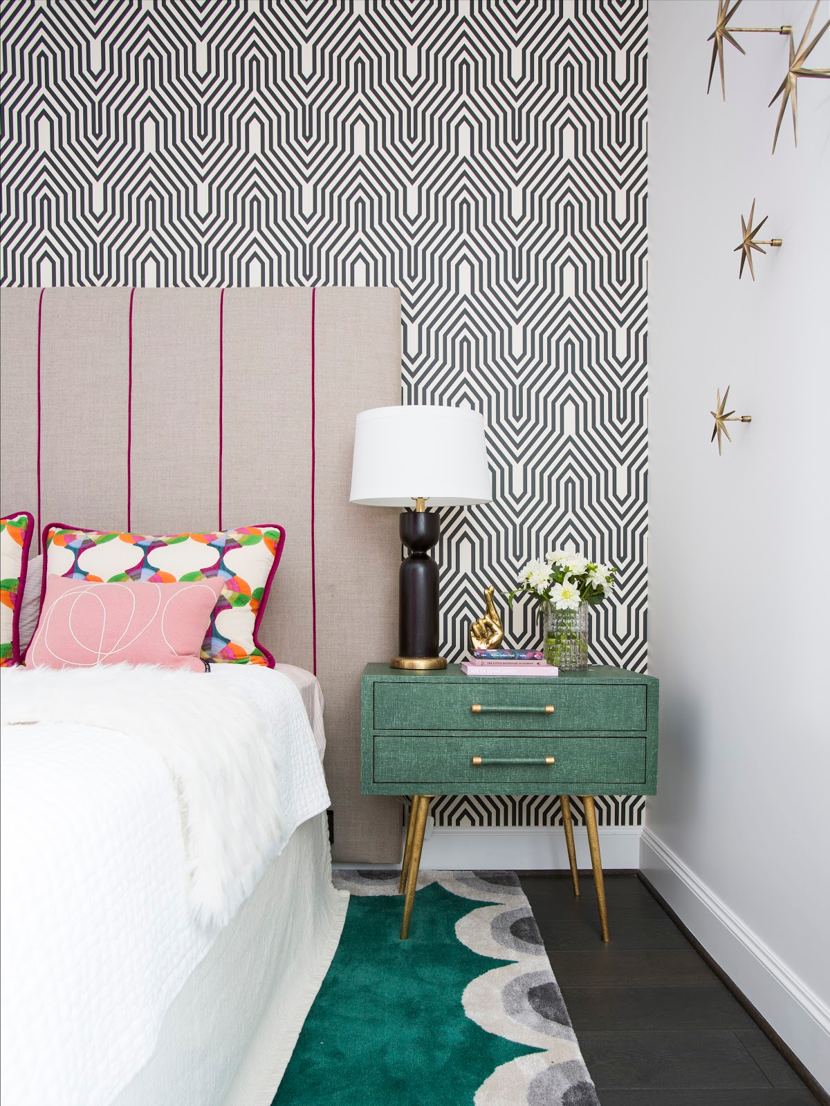 Geometric wallpaper covering as backdrop for custom pink stripe headboard in colorful guest bedroom - Laura U Interior Design